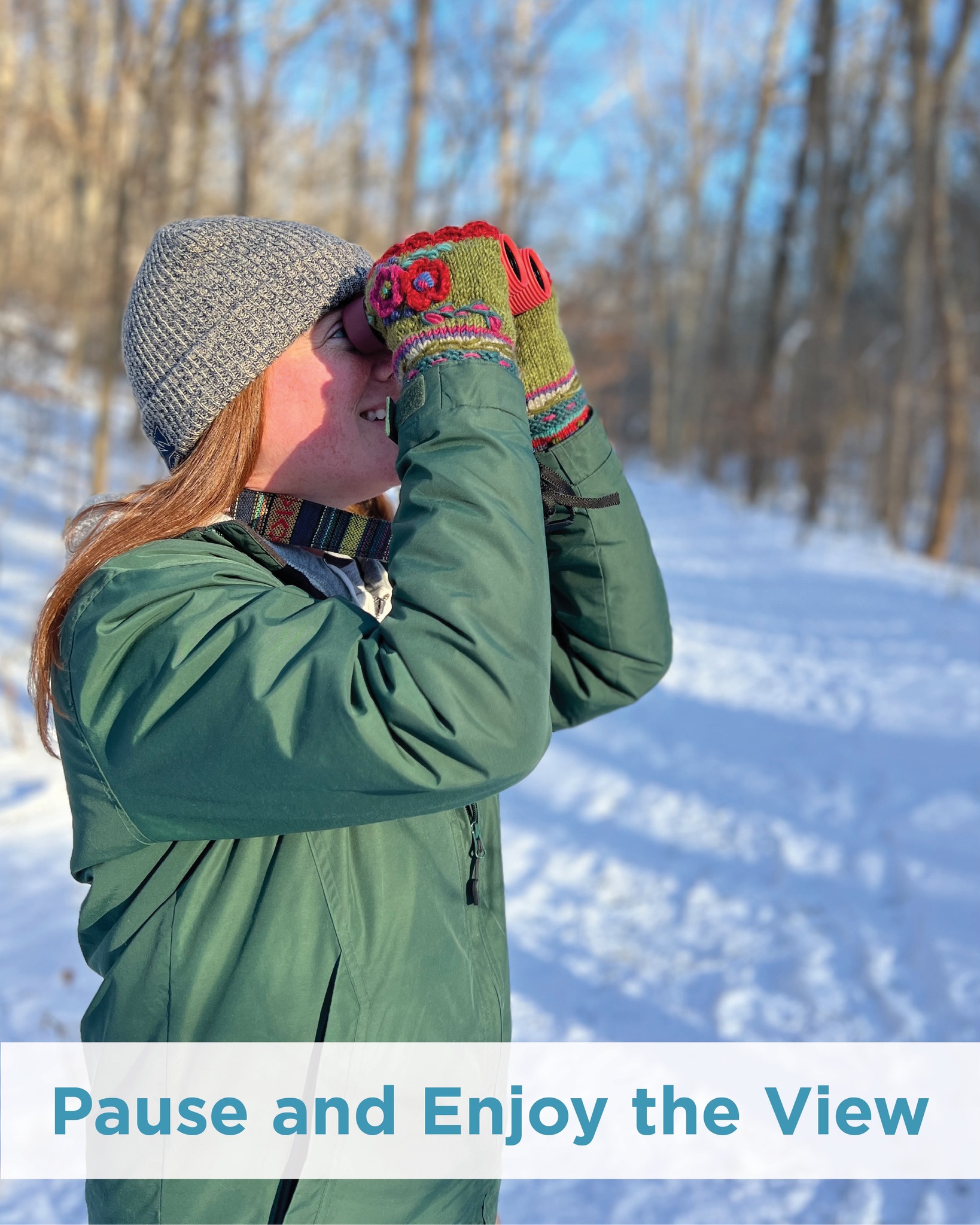 Woman looks through her binoculars in the snow.