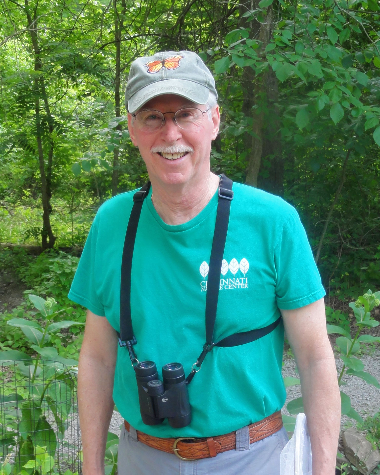 Steve Inglish with binoculars, standing outdoors.