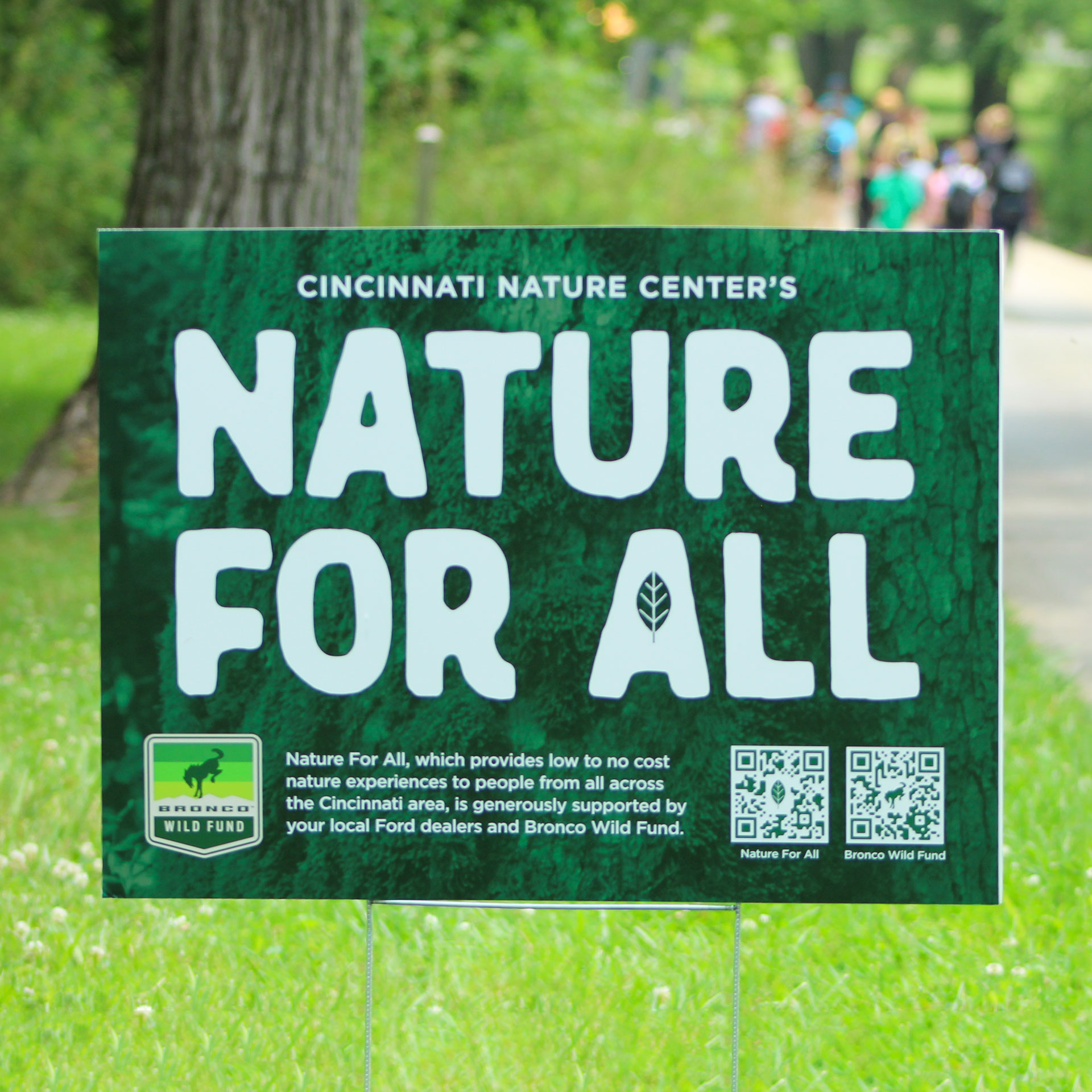 Nature for All sign behind a group of kids.