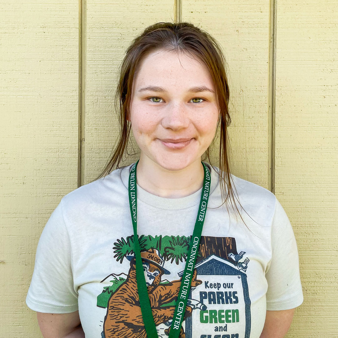 Hannah Gottenbusch in a white "Smokey the Bear" tshirt and green lanyard.