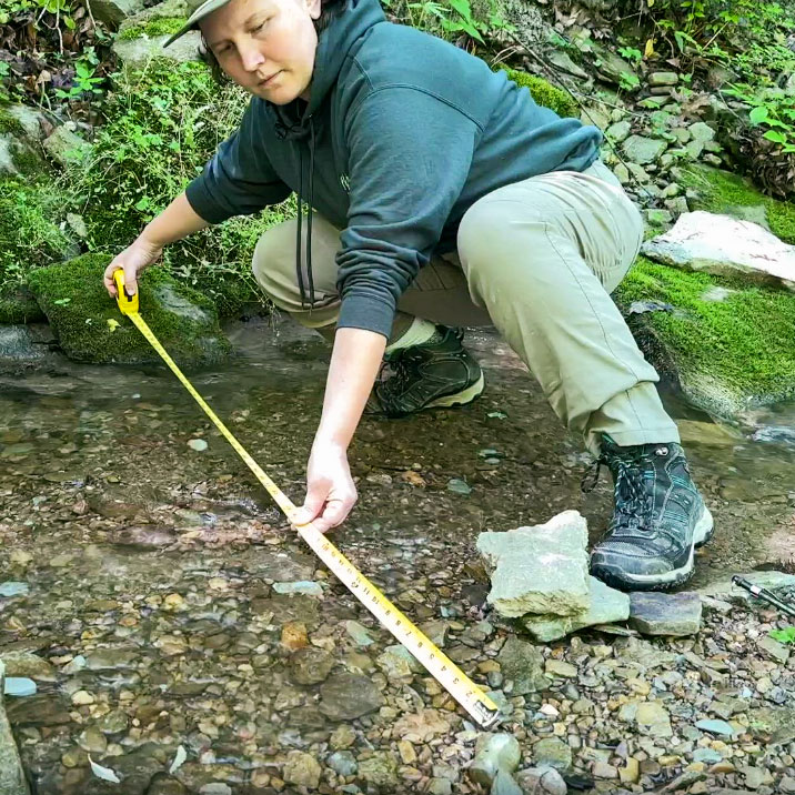 Tess measuring the width of a stream.