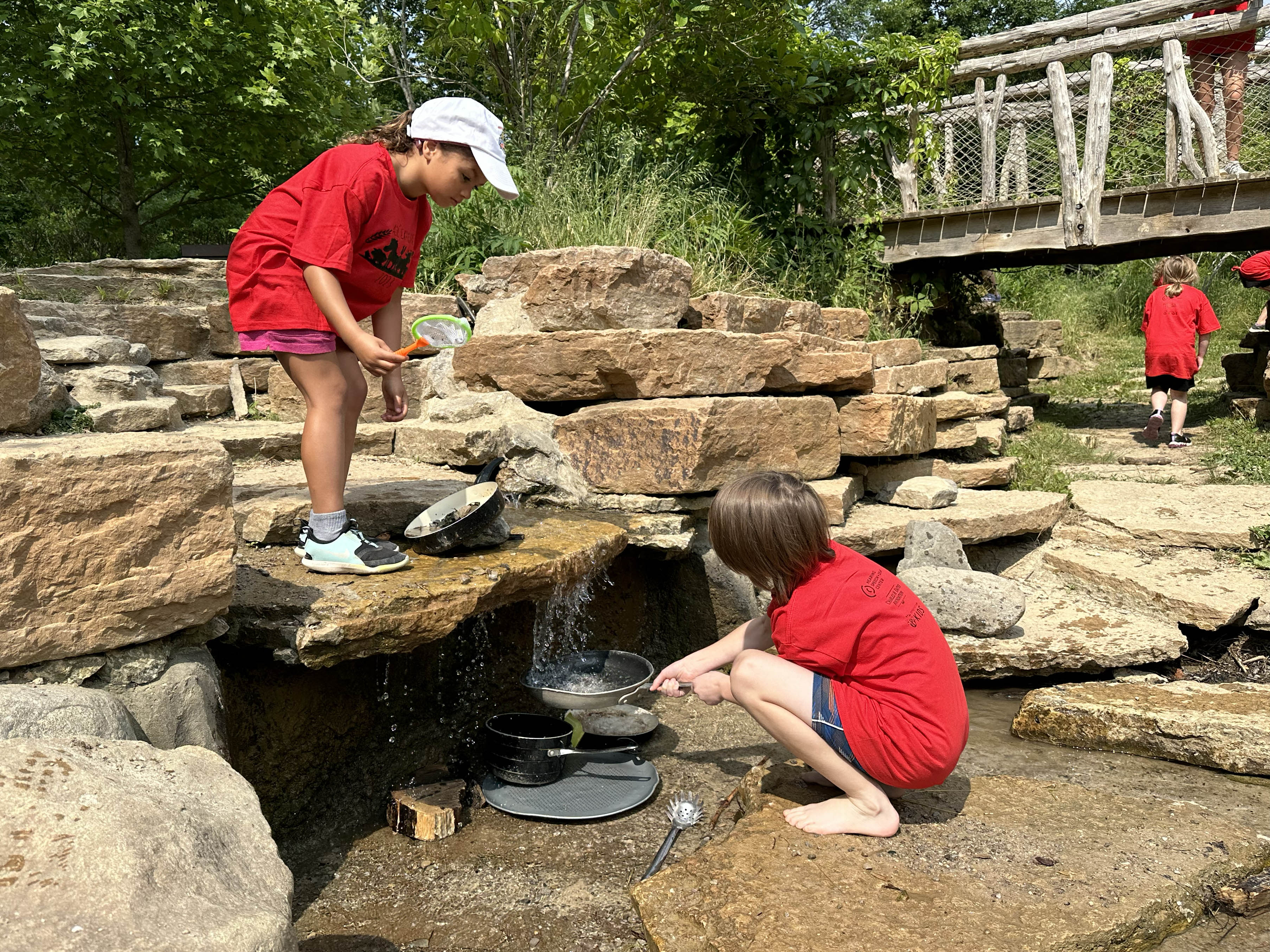 Photo of two children playing in a water feature at The Nature PlayScape